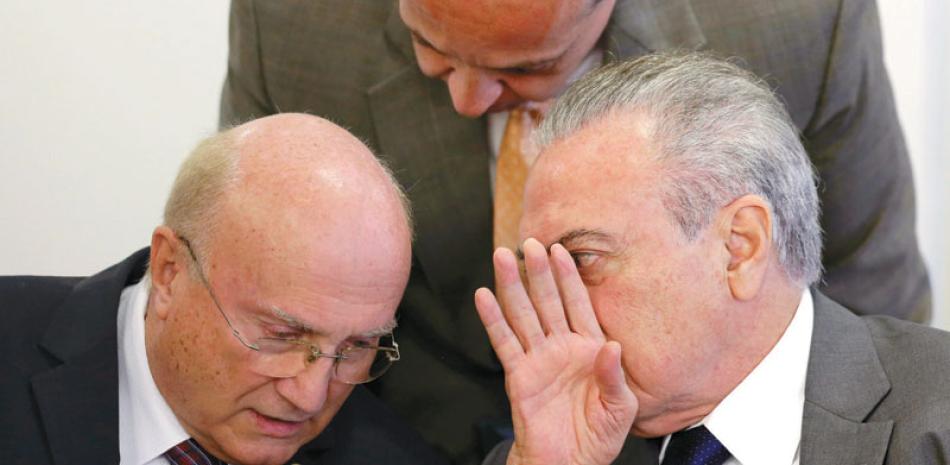 Conversación. El presidente de Brasil, Michel Temer, derecha, conversa con su ministro de Justicia, Osmar Serraglio, durante una ceremonia en el palacio de Planalto, el 12 de este mes.