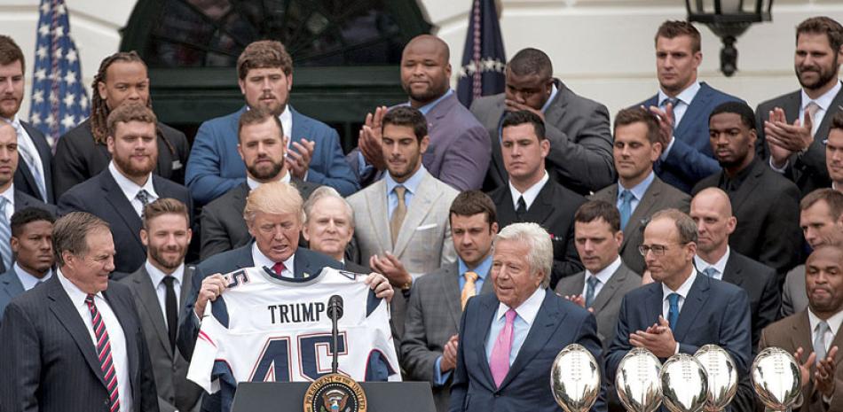Equipo. El presidente Donald Trump recibe una camiseta del equipo de fútbol americano New England Patriots, en la Casa Blanca, ayer. Siete jugadores no asistieron a la invitación, incluido el mariscal de campo, Tom Brady.