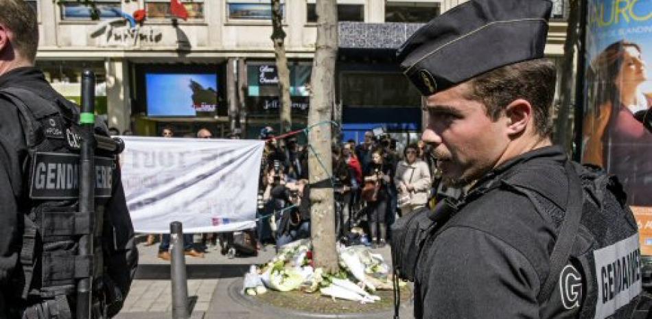 La policía vigila el lugar en el que fue asesinado anoche un policía durante un ataque yihadista perpetrado en la avenida de los Campos Elíseos de París (Francia).  EFE/Christophe Petit Tesson.
