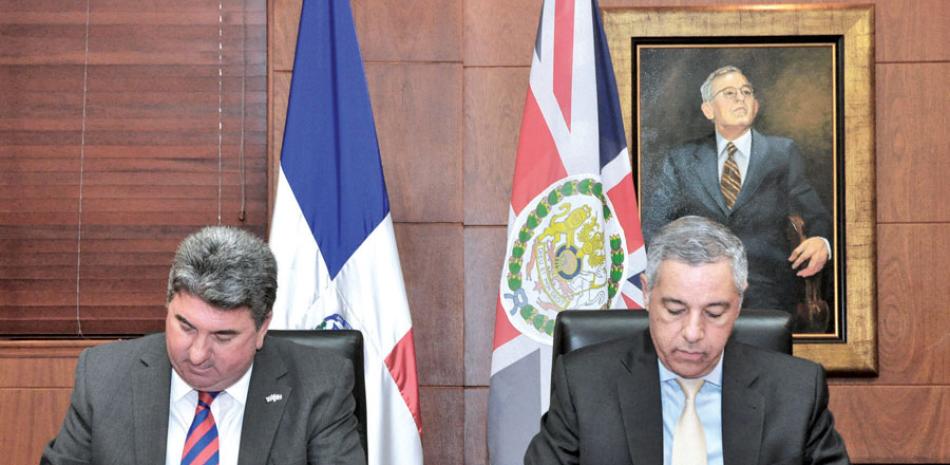 Firma. El embajador Christopher Campbell, y el ministro de Hacienda, Donald Guerrero, rubrican el acuerdo.