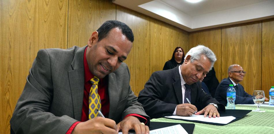 Firma. El alcalde de Tamboril, Anyolino Germosén León, rubrica el acuerdo junto al ministro de Economía, Isidoro Santana.