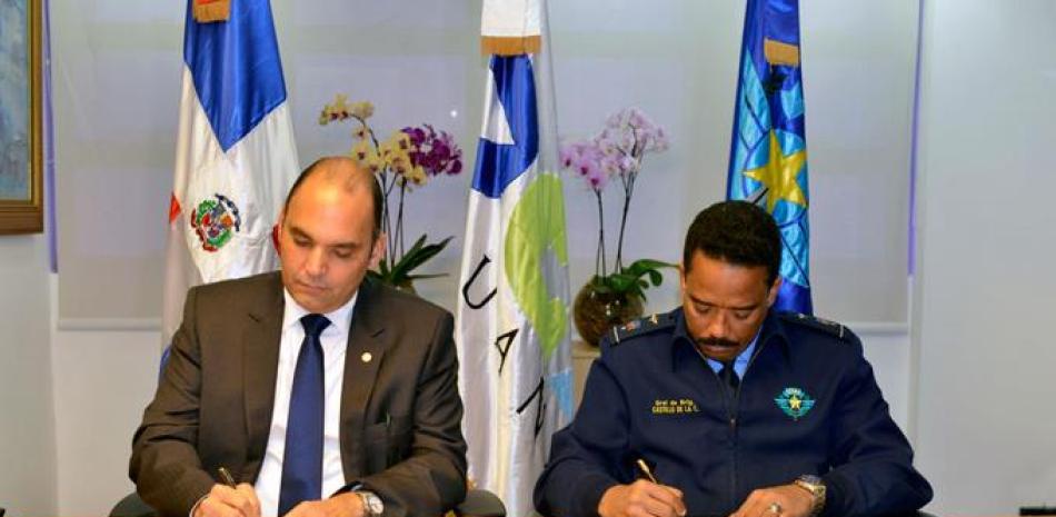 Acuerdo. El director de la DGA, Enrique Ramírez, firma el convenio junto al director del CESAC, general Aracenis Castillo de la Cruz.