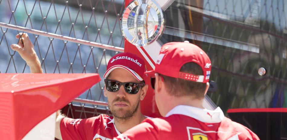 El piloto alemán de Fórmula Uno Sebastian Vettel, de Ferrari, conversa con su compañero de equipo, el finlandés Kimi Raikkonen.