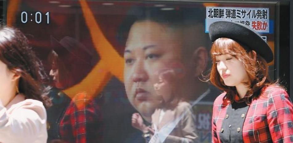 TV. Japoneses caminan frente a una televisora que transmite el informe sobre el lanzamiento del misil norcoreano, ayer en Tokío.