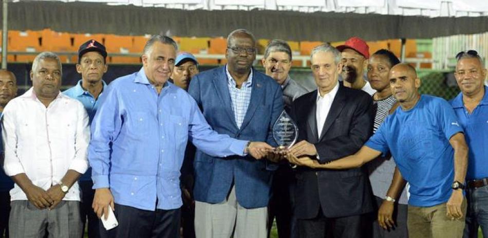 José Joaquín Puello recibe un reconocimiento de parte de Gerardo Suero Correa y Luisín Mejía, acompañados por el viceministro de Deportes Aníbal Portorreal y presidentes de asociaciones de atletismo del país.