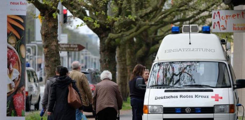 Residentes pasan junto a equipos de emergencias en Hannover-Vahrenfeld, en el norte de Alemania, durante el desalojo de 50.000 personas tras la aperición de supuestas bimbas de la IIGM sin explotar.