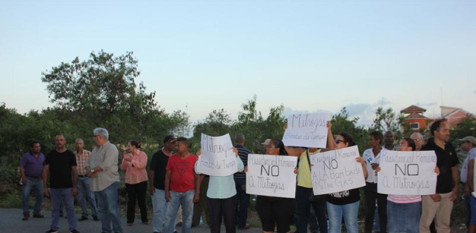 Opuestos Vecinos del Residencial Romana levantan carteles en una protesta contra la instalación de una planta de gas en el sector.