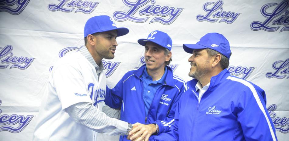 Luis Urueta estrecha las manos de Junior Noboa y Ricardo Ravelo minutos después de ser presentado de manera oficial como nuevo dirigente de los Tigres del Licey para el venidero torneo de béisbol invernal.