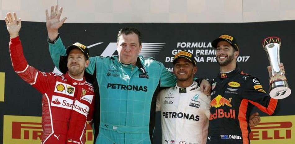 Lewis Hamilton, del equipo Mercedes, celebra su victoria en el Gran Premio de España de F1, junto a un mecánico de su equipo, y con el piloto de Ferrari Sebastian Vettel y el australiano de Red Bull, Daniel Ricciardo.