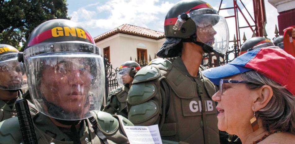 Manifestación. Una mujer grita consignas frente a integrantes de la Guardia Nacional Bolivariana durante la protesta, ayer en Caracas.