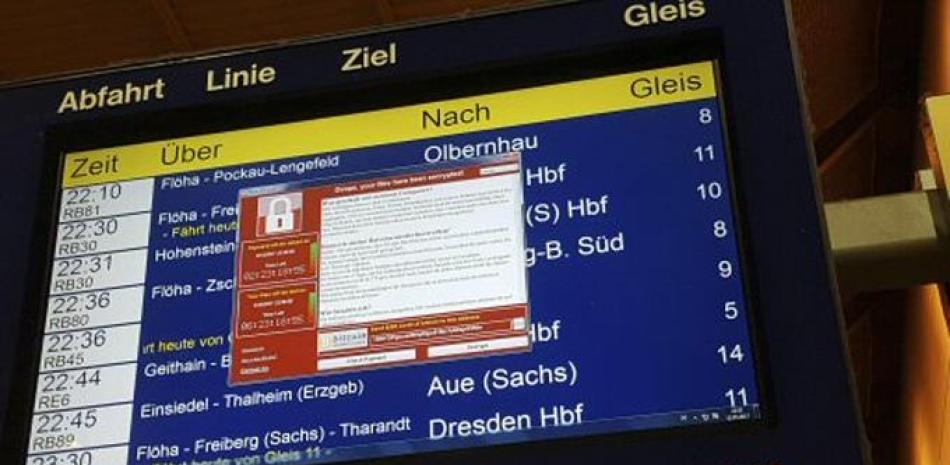 Un monitor con información de los trenes muestra una ventana con un mensaje de un programa informático malicioso que exige el pago de un rescate a cambio de devolver el control de la computadora, el 12 de mayo de 2017 en la estación de trenes de Chemnitz, Alemania. (P. Goezelt/dpa vía AP)