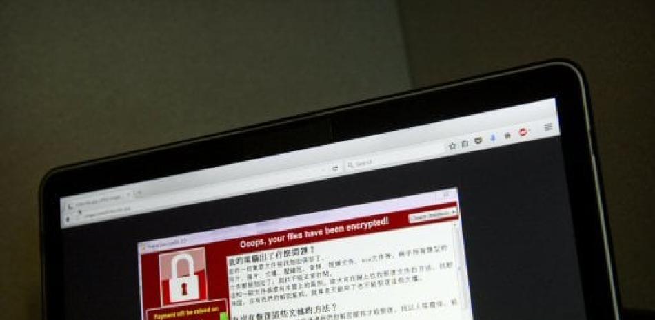 En la imagen, una pantalla muestra el mensaje de advertencia de un supuesto ciberataque que secuestra el equipo, en una imagen de pantalla tomada por un usuario en Taiwán y vista a través de un laptop en Beijing, el sábado 13 de mayo de 2017. (AP Foto/Mark Schiefelbein)