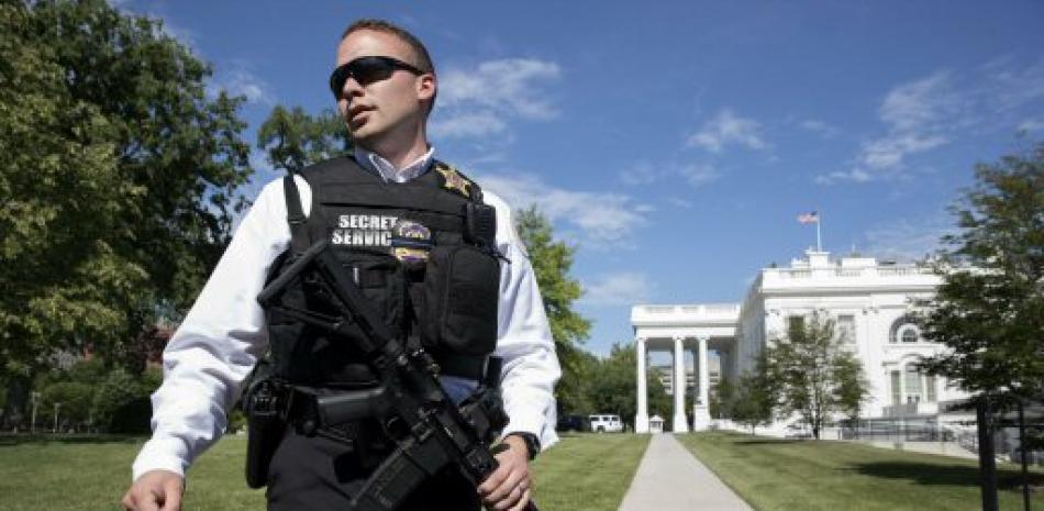 Un integrante del Servicio Secreto de EE.UU. retira a periodistas, luego de que alguien intentara cruzar una reja en el Patio Norte de la Casa Blanca en Washington .