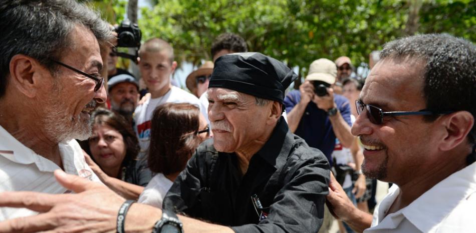 Compañeros. Los exprisioneros Luis Rosa, derecha, y Adolfo Matos, le dan la bienvenida a Oscar López Rivera, quien llegó a la Plaza El Escambron tras su liberación de arresto domiciliario, ayer en San Juan.