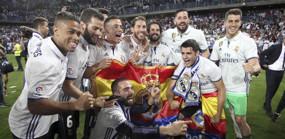Los jugadores del Real Madrid celebran la consecución del título de liga a la finalización del encuentro correspondiente a la última jornada de Primera División, que han disputado frente al Málaga en el estadio de la Rosaleda, en Málaga.
