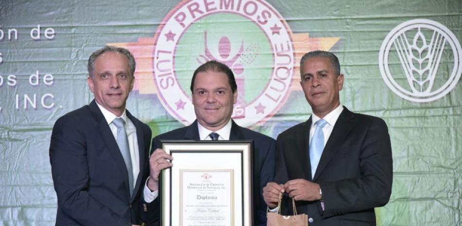Kevin Cabral, cronista del año, es premiado por Luis Rubio, de Cervecería Nacional Dominicana y Américo Cabrera, presidente de la ACDS.