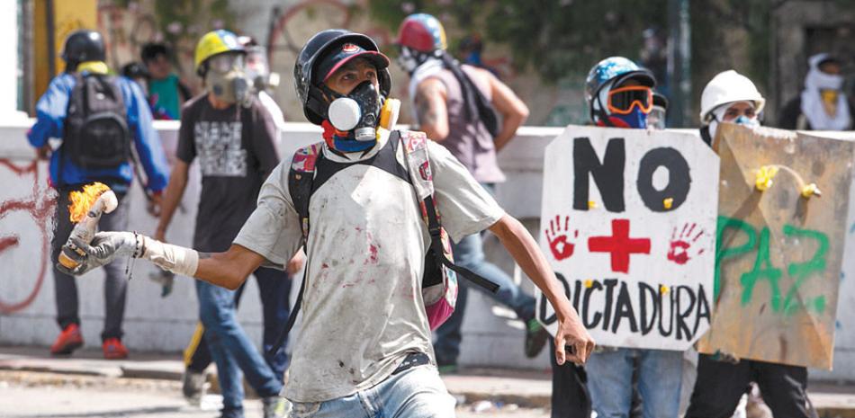 Calle. Manifestantes opositores se enfrentan a integrantes de la Guardia Nacional Bolivariana, durante una marcha en contra del gobierno, ayer.