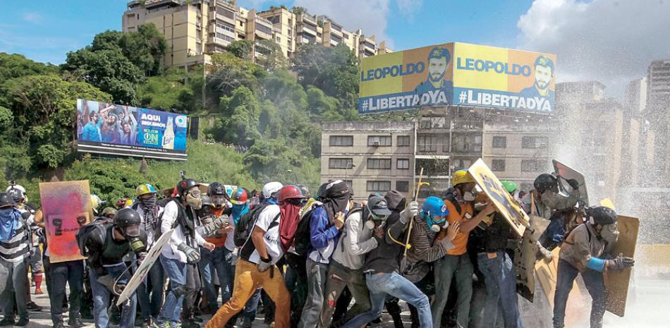 Choques. Opositores al gobierno venezolano se enfrentan a miembros de la Policía Nacional Bolivariana en una manifestación ayer en Caracas.