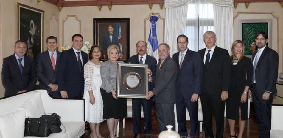 Distinción. El presidente Danilo Medina junto a los principales dirigentes de la Asociación Dominicana de Productores de Cemento Portland (Adocem), que ayer le rindieron un reconocimiento por su aporte al sector.