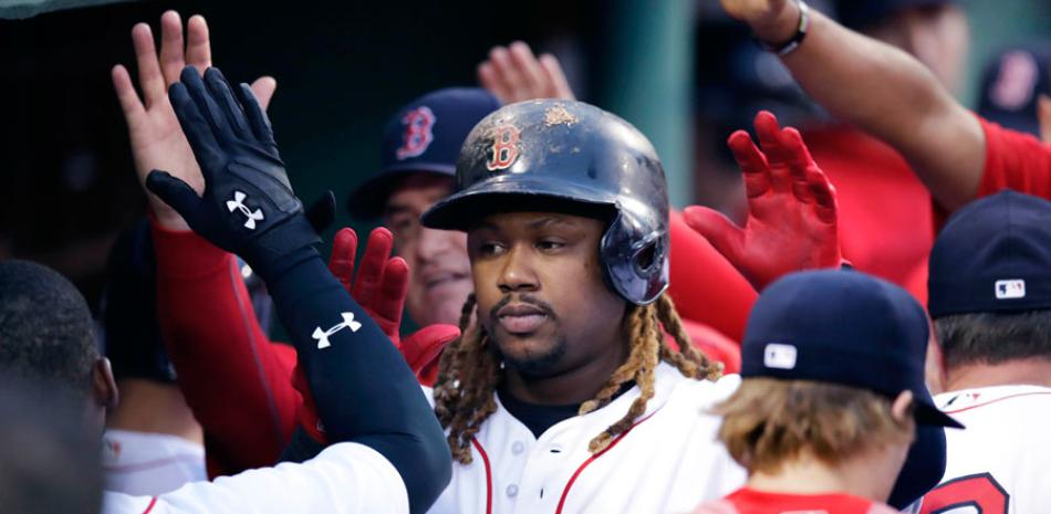 Hanley Ramírez es felicitado por varios de sus compañeros luego de disparar un jonrón que abrió el marcador para los Medias Rojas.