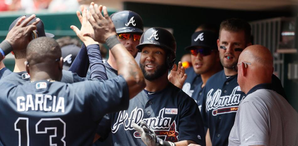 Danny Santana es felicitado por varios compañeros al arribar al dugout luego de batear su primer vuelacercas con los Bravos.