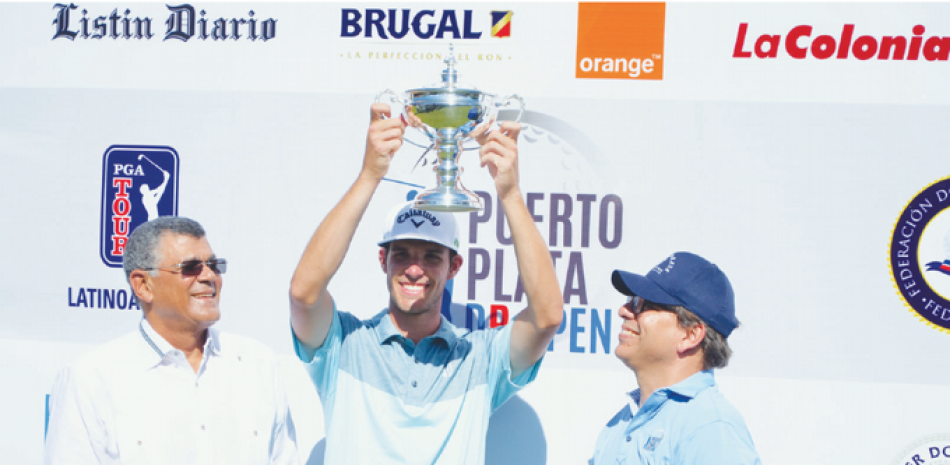 Tee-K Kelly levanta el trofeo de campeón del Puerto Plata DR Open 2017. Observan Rafael Villalona, Presidente de FEDOGOLF, y Paul Brugal, Presidente del Playa Dorada Golf Club.