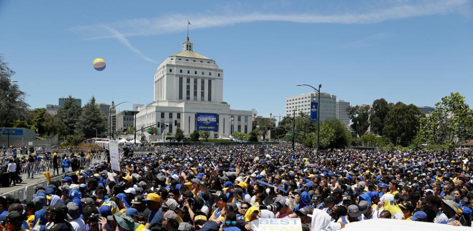 Fanáticos de los Warriors de Golden State celebran durante el desfile de los campeones de la NBA por la ciudad de Oakland.
