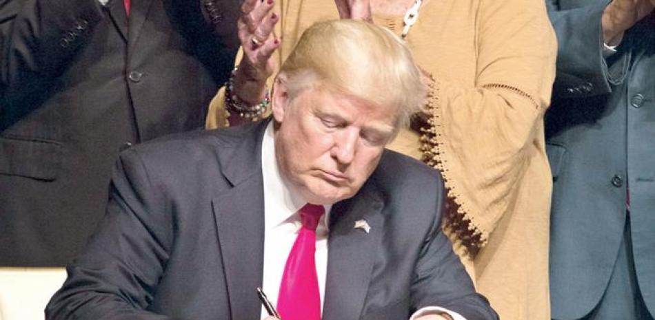 Acto. El presidente Donald Trump firma la orden ejecutiva sobre la nueva política con Cuba, en Miami, Florida.