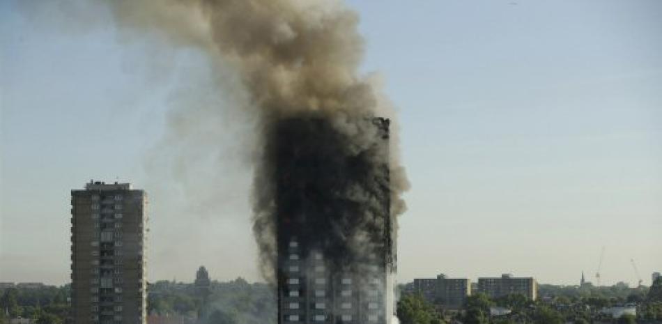 ARCHIVO - En esta fotografía de archivo del 14 de junio de 2017, hubo sale de una torre de apartamentos de 24 niveles debido a un incendio en Londres. Expertos afirman que a pesar del alto número de víctimas en el lugar, el “permanezcan donde están” continúa siendo la mejor recomendación en caso de que ocurra un incendio en otro lugar de un edificio de gran altura.( AP Foto/Matt Dunham, Archivo).