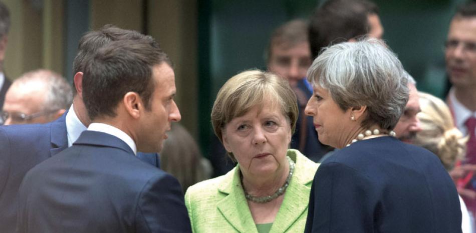 Caso. La canciller alemana, Angela Merkel, al centro, conversa con la primera ministra británica, Theresa May, derecha, y el presidente galo, Emmanuel Macron, izquierda, en Bruselas, ayer.