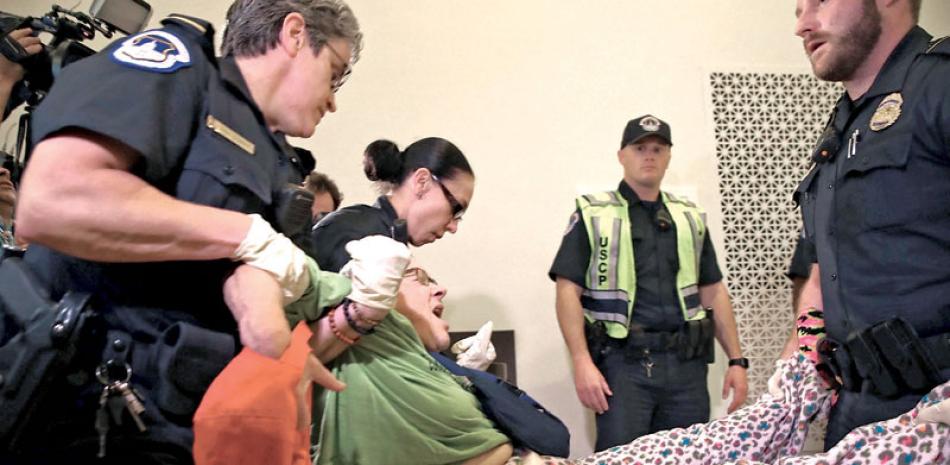 Discapacitados. La policía del Capitolio saca a una mujer que protestaba frente a la oficina del líder de la Mayoría en el Senado, Mitch McConnell, dentro de la ofidina del congresista, en Capitol Hill.