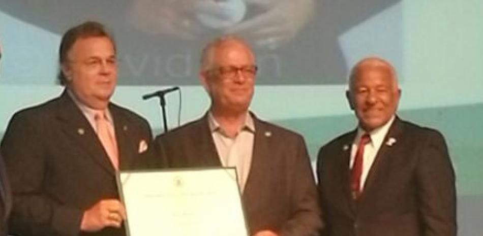 Placa. Miguel Fiallo Calderón, rector de la UNPHU, premia a Ricky Noboa, junto a Rolando Miranda.