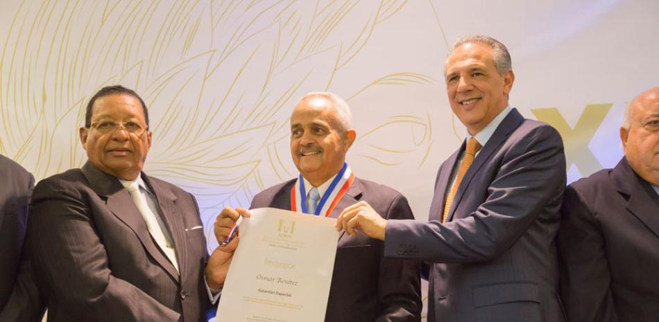 El presidente de la ADHA, Julio de Beras, y el ministro José Ramón Peralta, entregan a Osmar Benites un reconocimiento.