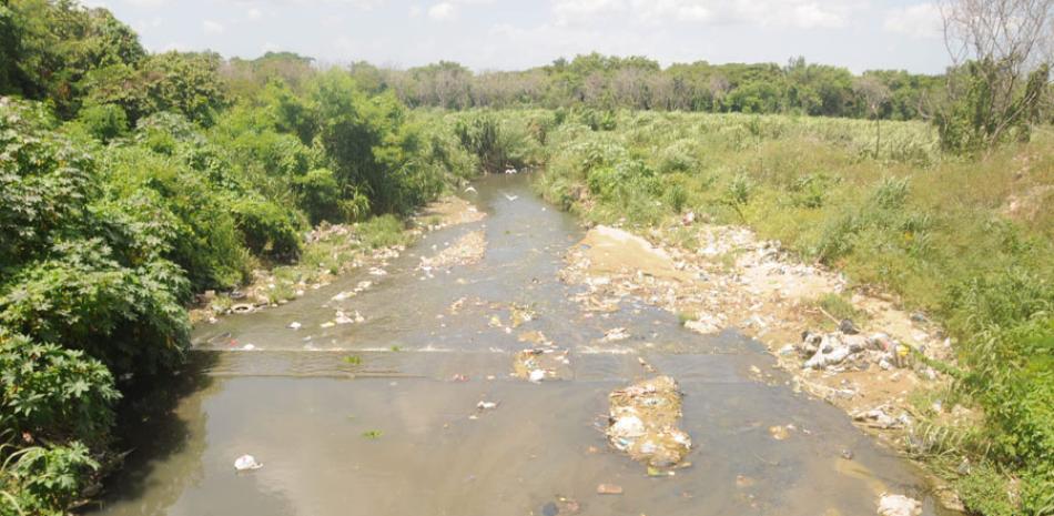 Contaminación. Vista de un tramo de agua del río Yaque del Norte con cúmulos de basura y otro tipo de desechos en su cauce.