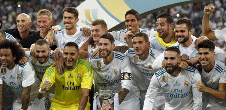 Jugadores del Real Madrid posan con el trofeo de campeón tras conquistar la supercopa, tras derrotar al Barcelona.