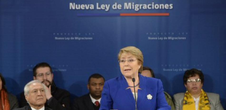 Fotografía cedida por la Presidencia de Chile, de la mandataria Michelle Bachelet (c) durante su discurso después de firmar el Proyecto de nueva Ley de Migraciones hoy, lunes 21 de agosto de 2017, en Santiago (Chile).