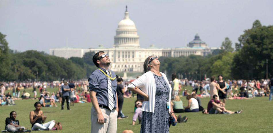 Alegría. Personas observan el eclipse solar desde el National Mall, en Washington D.C.,Estados Unidos, ayer. El acontecimiento tardó una hora y media en recorrer el cielo estadounidense desde la costa del Pacífico.