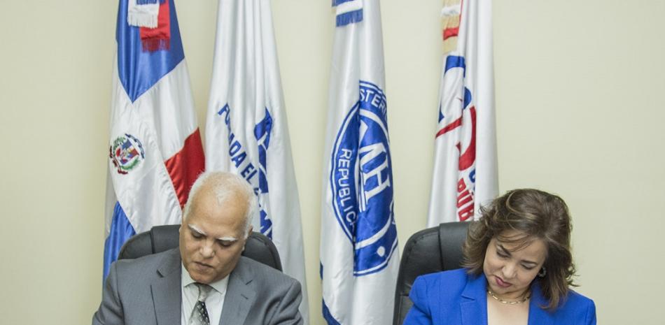 El presidente de Codopyme, Issachart Burgos y la directora de Compra y Contrataciones Públicas, Yokasta Guzmán, rubrican el acuerdo.