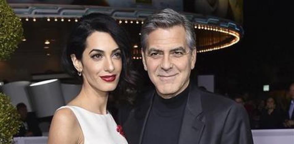 En esta foto del 1 de febrero del 2016, Amal Clooney, a la izquierda, y George Clooney llegan al estreno mundial de "Hail, Caesar!" en Los Angeles. Clooney dirige el filme de próximo estreno "Suburbicon", protagonizado por Matt Damon, Oscar Isaac y Julianne Moore. (Foto por Jordan Strauss/Invision/AP, Archivo)