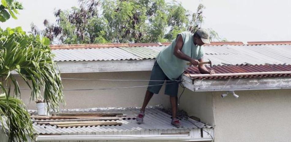 Un propietario hace reparaciones de última hora en su tejado en preparación del huracán Irma, en St. John’s, Antigua y Barbuda, el martes 5 de septiembre de 2017. (AP Foto/Johnny Jno-Baptiste).