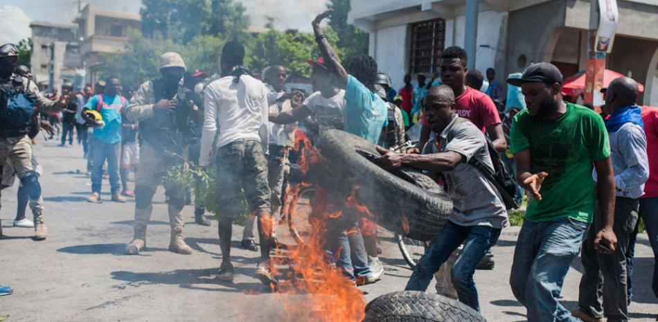 Protesta. Manifestantes arman una barricada ayer, en Puerto Príncipe, durante la protesta contra la la aprobación por parte del Parlamento del Presupuesto Nacional, en el cual se aumentaban los impuestos.