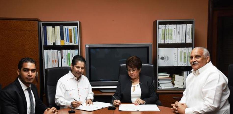 Firma. Alejandrina Germán y José Aníbal García, firmaron el acuerdo. Observa el exvicepresidente Jaime David Fernández Mirabal.