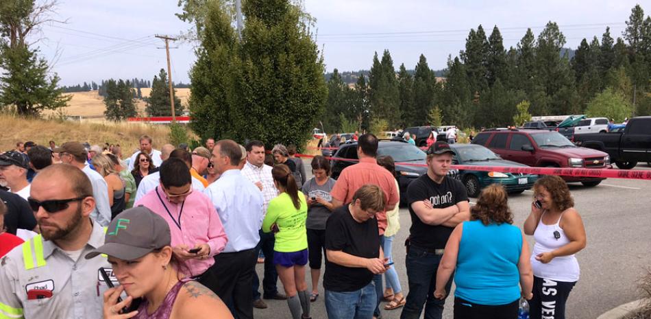 Violencia. Padres se reúnen ayer en el estacionamiento detrás de la Escuela Secundaria Freeman en Rockford, Washington, mientras esperaban la salida de sus hijos luego del tiroteo.