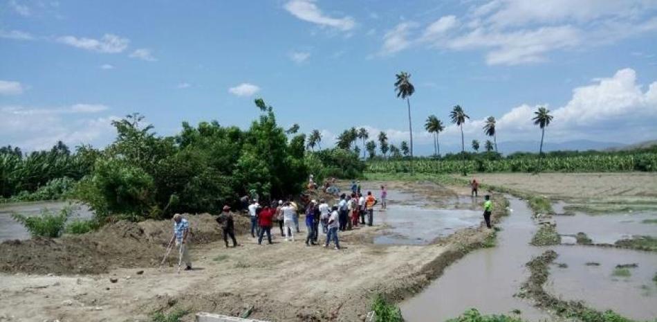 Moradores de Jaquimeyes abren un boquete al río Yaque del Sur, zona de Canoa, para evitar afluente se desborde e inunde sus casas.