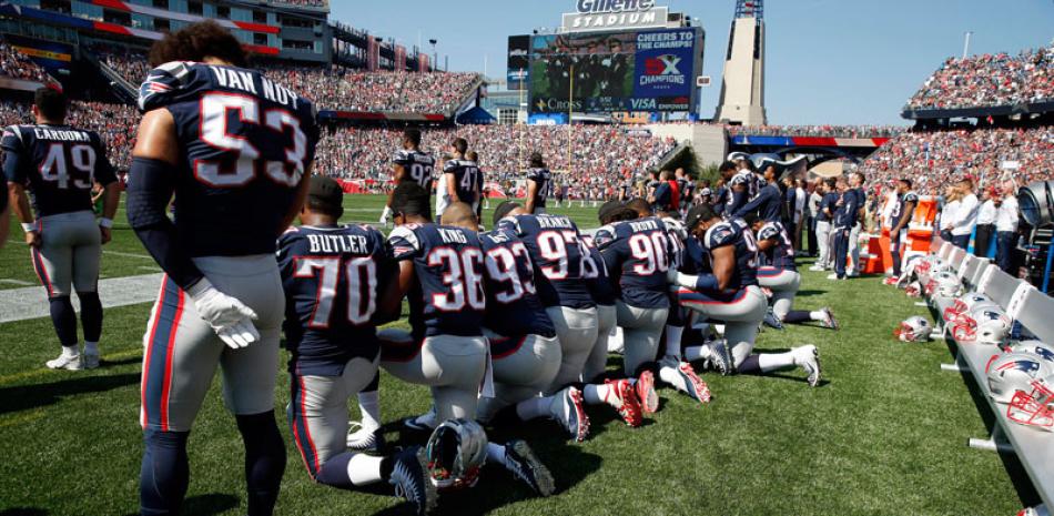 Varios jugadores de los Patriots de New England se arrodillan durante el himno nacional ante del partido de la NFL contra los Texans de Houston ayer en Foxborough.