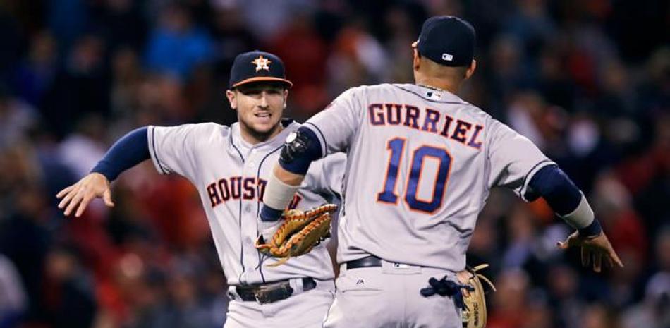 Alex Bregman, de los Houston Astros, y Yuli Gurriel (10) celebran después de que los Astros derrotaron a los Medias Rojas de Boston por 3-2.