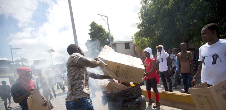 Impuestos. Manifestantes incendian una barricada ayer, durante una protesta contra el aumento de los impuestos en la capital, Puerto Príncipe.