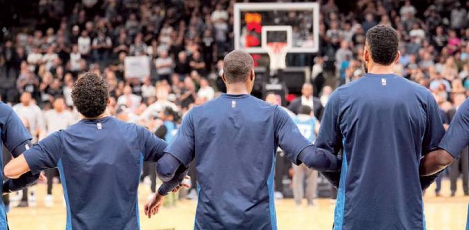 Los Spurs y Timberwolves estuvieron de pie durante el himno nacional como de costumbre. Pero después del himno, ambas escuadras entrelazaron sus brazos en sus respectivas esquinas de la cancha.
