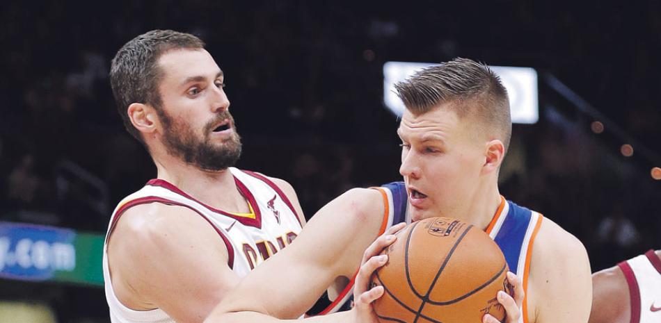 Kristaps Porzingis, de los Knicks, trata de avanzar hacia el canasto ante la defensa de Kevin Love, de los Cavaliers, en acción de ayer en la NBA.