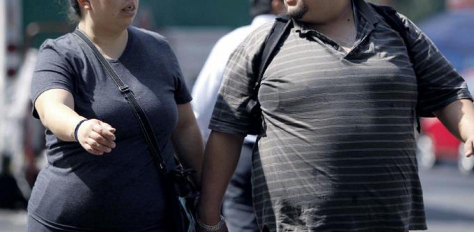 Epidemia. Dos personas con sobrepeso caminan en Ciudad de México, en México, una de las naciones de Latinoamérica con las tasas más elevadas de diabetes por obesidad. En esa nación buscan nuevos protocolos no invasivos, como una terapia que reduce el apetito, como respuesta para combatir la obesidad, declarada como epidemia en el país hace un año.